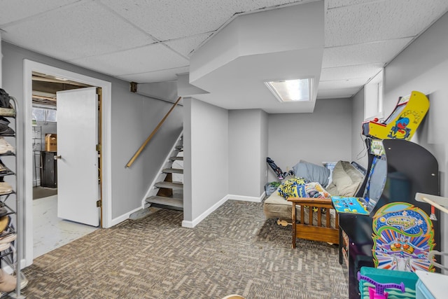 recreation room featuring carpet, baseboards, and a drop ceiling