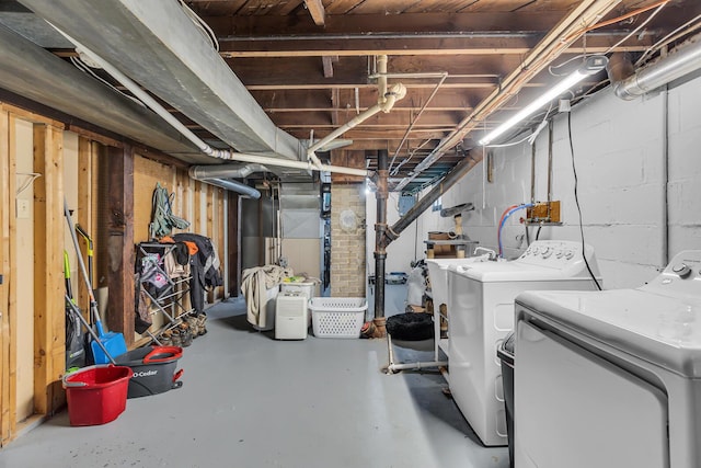 unfinished below grade area with washing machine and clothes dryer