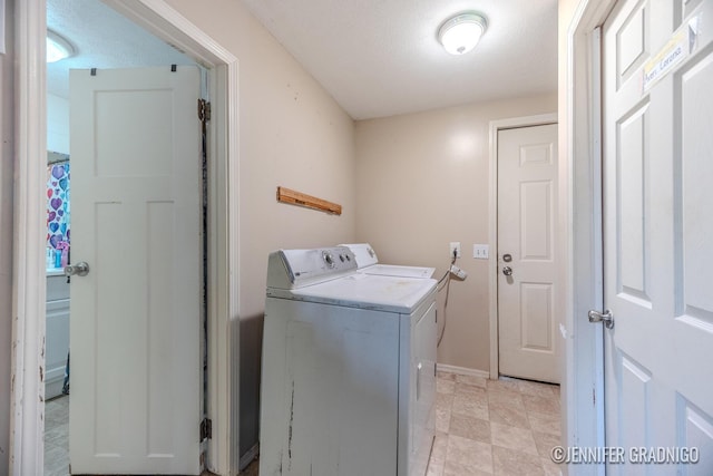 laundry area with laundry area, a textured ceiling, and washer and dryer