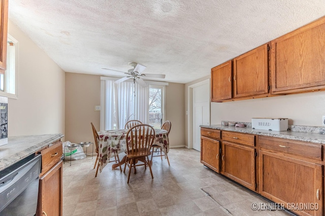 interior space featuring a ceiling fan, a textured ceiling, and baseboards