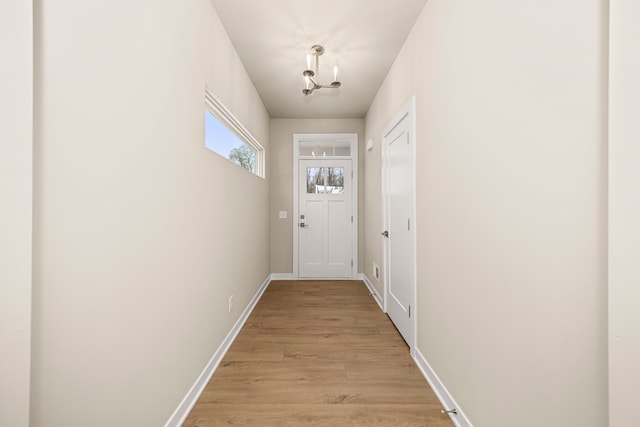 doorway featuring light wood finished floors and baseboards