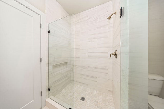 full bathroom featuring a stall shower and toilet