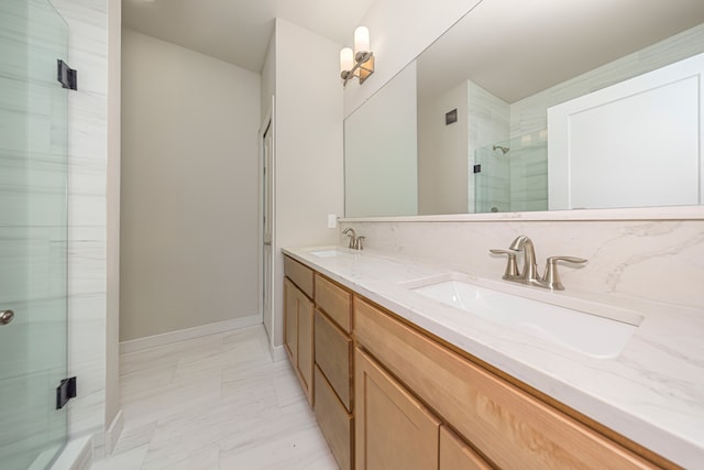 bathroom with a sink, a shower stall, baseboards, and double vanity