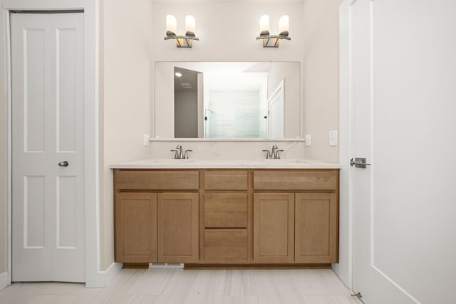 full bathroom with double vanity, a shower stall, and a sink