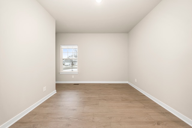 unfurnished room featuring light wood-type flooring and baseboards