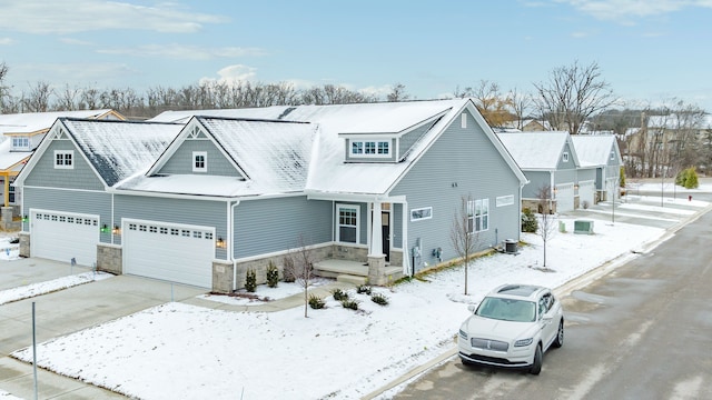 view of front of property featuring a garage, a residential view, stone siding, and concrete driveway