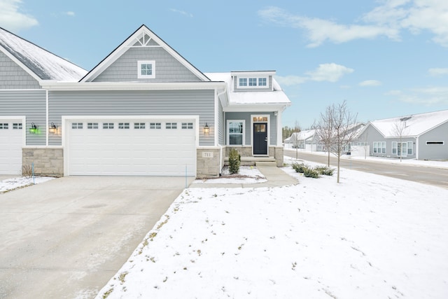 view of front of home featuring an attached garage, driveway, and stone siding