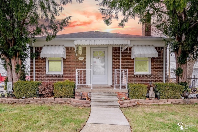 bungalow-style house featuring a chimney and brick siding