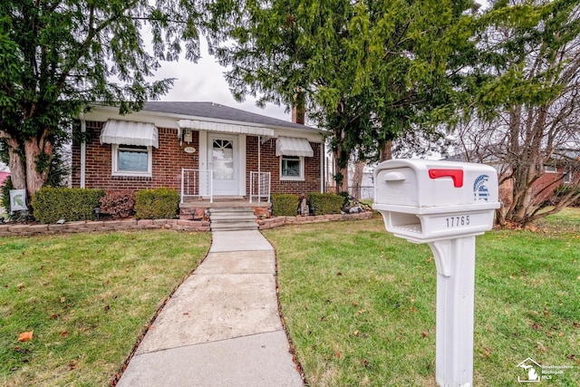 view of front of house with a front yard and brick siding