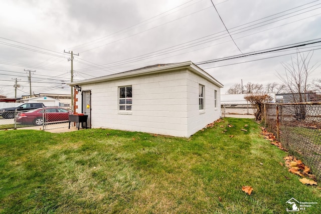 view of side of home featuring a fenced backyard and a yard