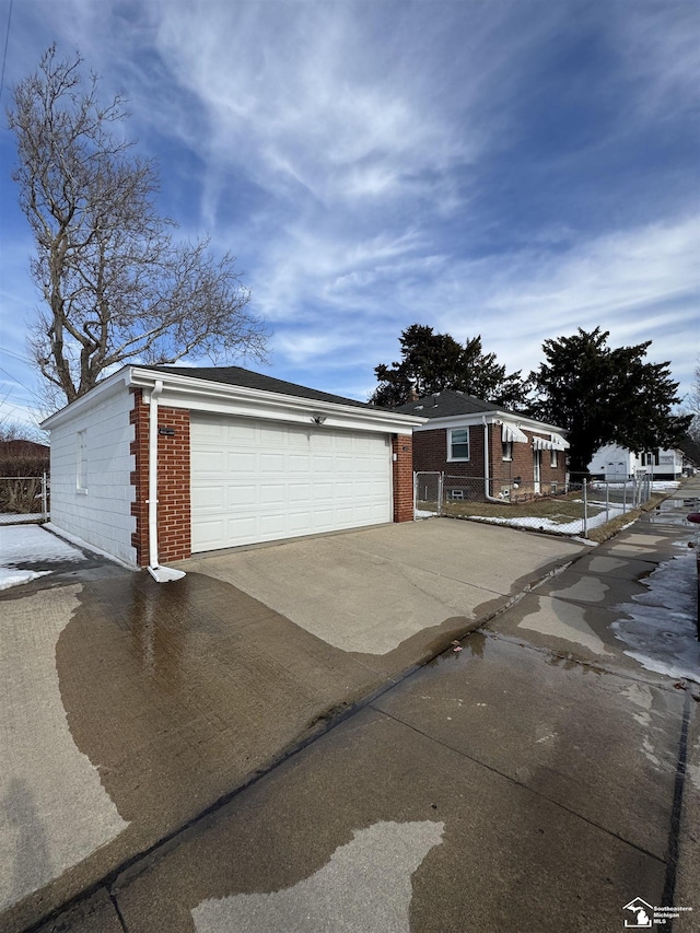 view of front of home featuring brick siding and a detached garage