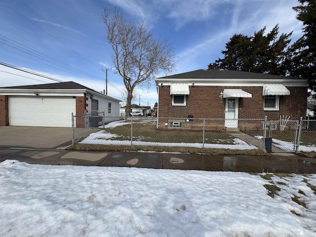 view of front of house featuring a fenced front yard, brick siding, a gate, a garage, and driveway