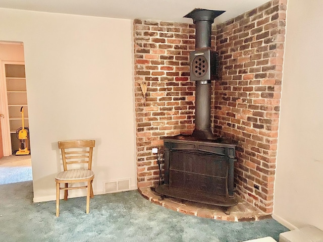 interior details with carpet floors, a wood stove, and visible vents