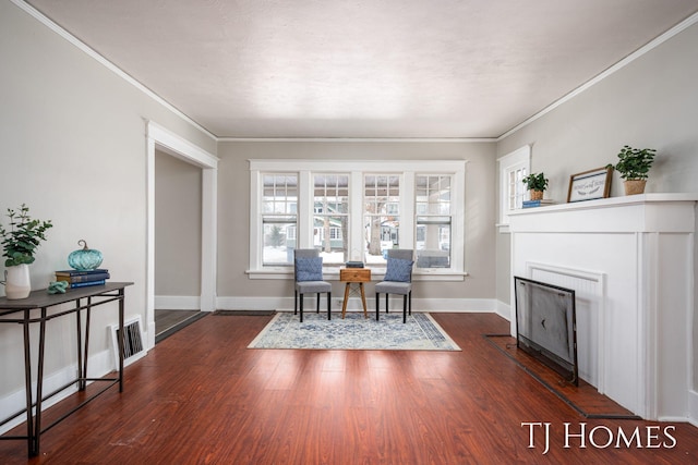 sitting room with a fireplace, crown molding, baseboards, and wood finished floors