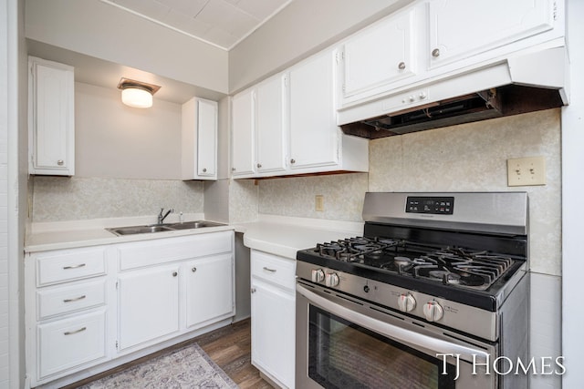 kitchen with stainless steel range with gas cooktop, white cabinetry, a sink, and under cabinet range hood