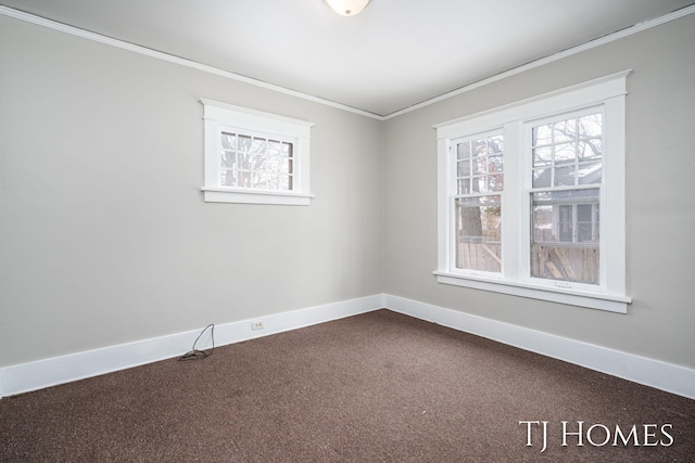 empty room featuring crown molding, dark carpet, plenty of natural light, and baseboards