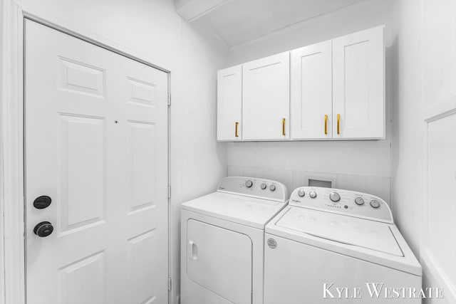 laundry room with washing machine and clothes dryer and cabinet space