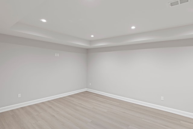 empty room with light wood finished floors, baseboards, visible vents, and recessed lighting