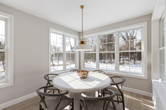 dining space featuring baseboards and light wood-style floors