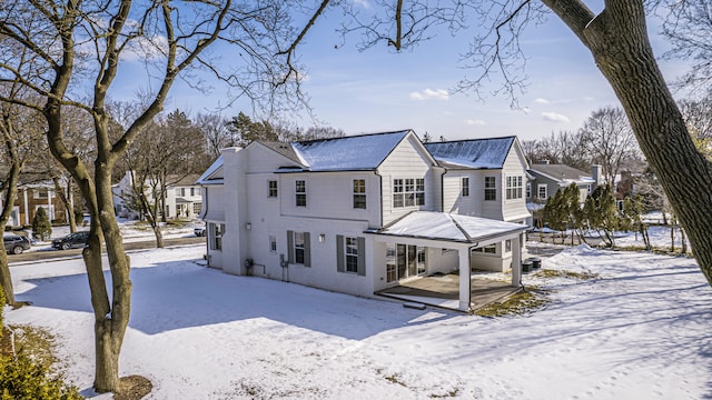 snow covered house with a residential view and a patio