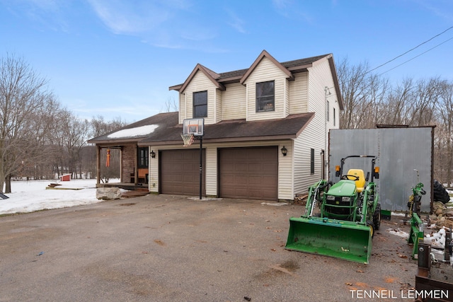 view of side of home with aphalt driveway and roof with shingles