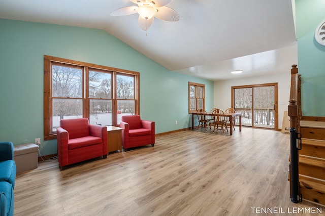 living area with lofted ceiling, ceiling fan, baseboards, and wood finished floors