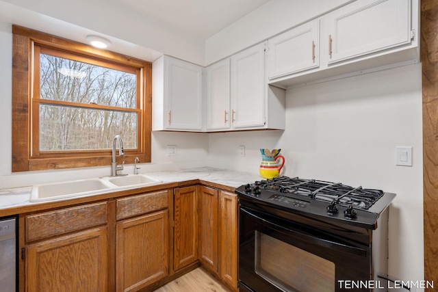 kitchen with light countertops, gas stove, white cabinets, a sink, and dishwasher