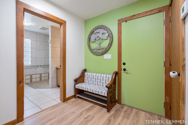 foyer entrance featuring visible vents, baseboards, and wood finished floors