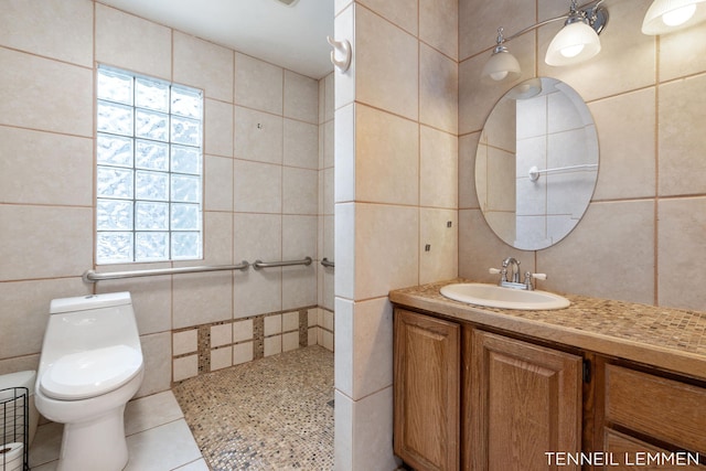 bathroom featuring toilet, tile patterned flooring, tile walls, and vanity