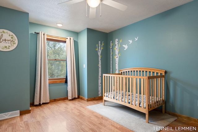 bedroom featuring visible vents, baseboards, and wood finished floors