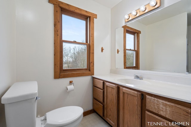 bathroom with baseboards, vanity, toilet, and tile patterned floors