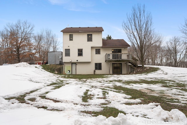 snow covered property featuring a deck and stairway