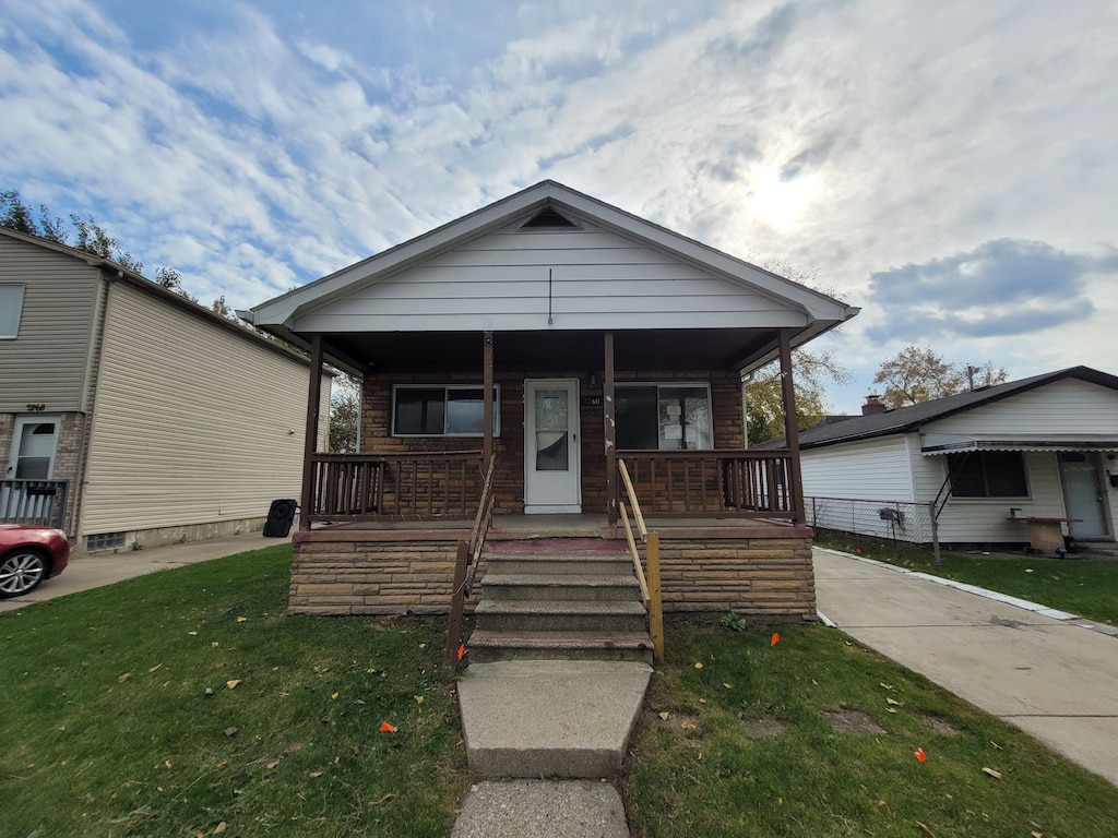 view of front of property featuring covered porch and a front yard