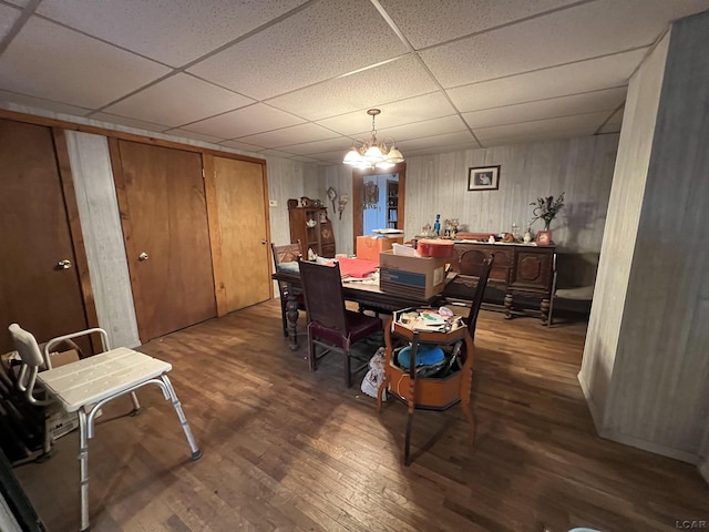 dining room featuring an inviting chandelier, a drop ceiling, and wood finished floors