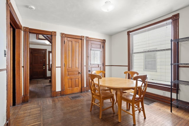 dining area with visible vents, dark wood finished floors, and baseboards