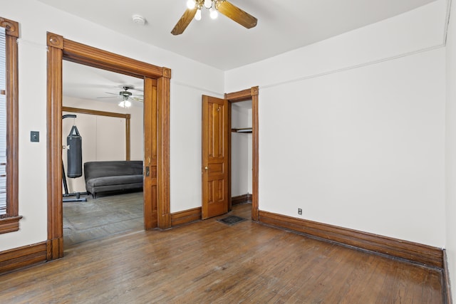 empty room featuring hardwood / wood-style flooring, baseboards, and a ceiling fan