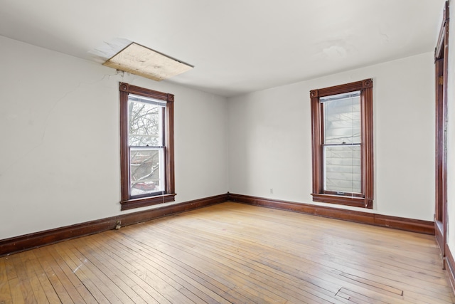 unfurnished room with light wood-style flooring and baseboards