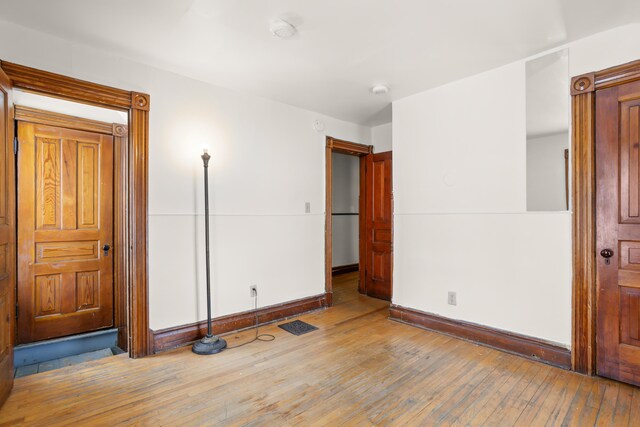 unfurnished bedroom featuring hardwood / wood-style flooring and baseboards