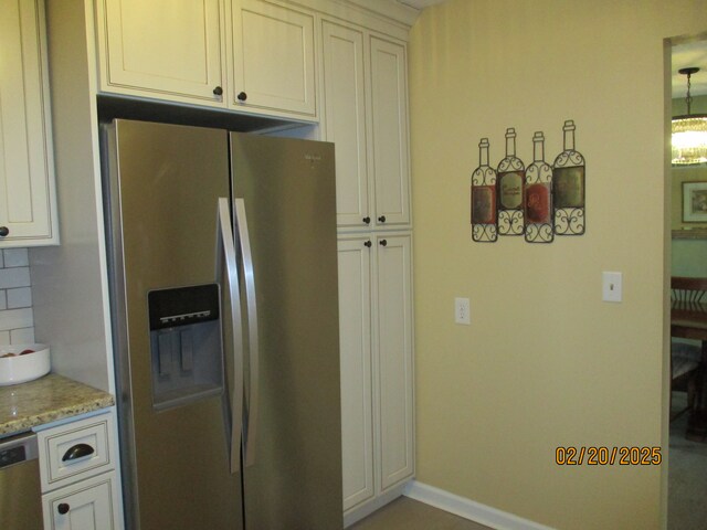 kitchen with stainless steel appliances, baseboards, decorative backsplash, light stone countertops, and pendant lighting