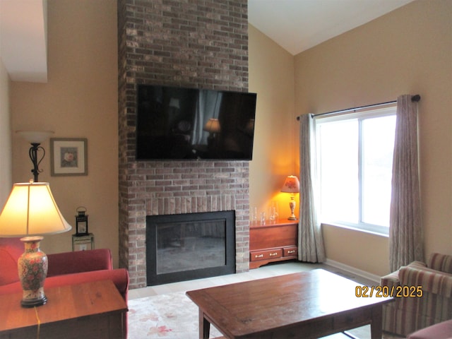 living area featuring lofted ceiling and a brick fireplace