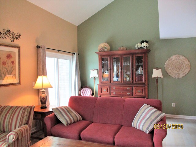 living room with lofted ceiling and baseboards