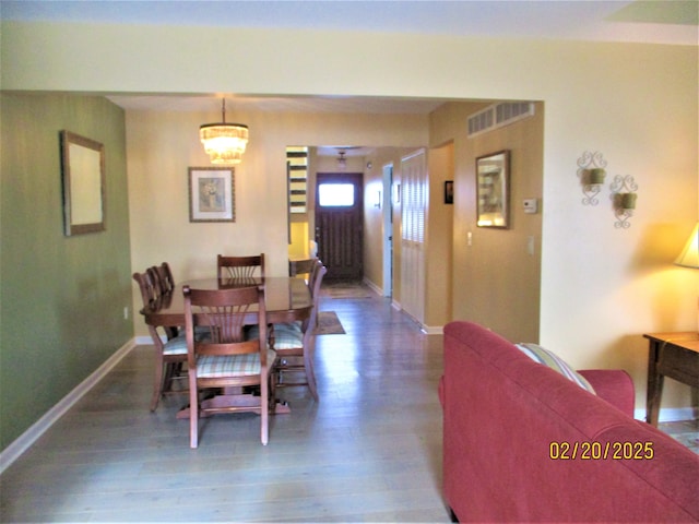 dining area with visible vents, baseboards, and wood finished floors