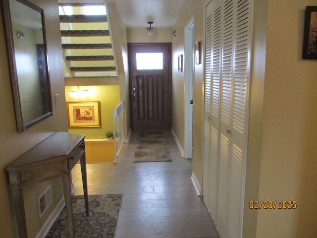 doorway featuring wood-type flooring, visible vents, and baseboards