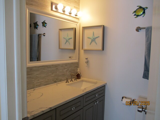 bathroom with tasteful backsplash and vanity