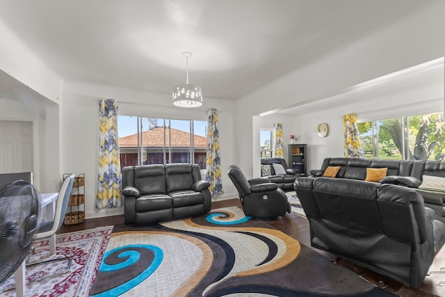 living area with a notable chandelier, baseboards, and wood finished floors