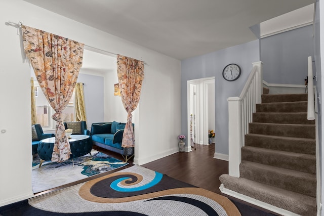 living area with stairs, baseboards, and wood finished floors