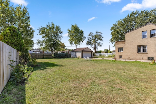 view of yard with an outbuilding, a fenced backyard, and a detached garage