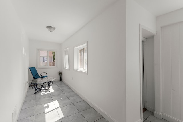 hallway with baseboards and light tile patterned floors