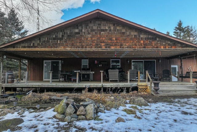 snow covered property featuring a wooden deck