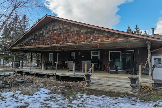 snow covered rear of property featuring a wooden deck